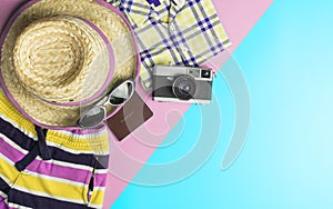 Summer fashion and accessories travel top view flatlay on blue pink pastel