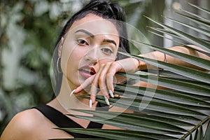 Summer fashion beauty portrait. Close up of face of beautiful Asian Japanese woman with long dark hair, wearing black