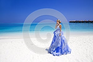 Summer fashion. Elegant fashion model. Glamour, stylish female model in elegant long gown dress on the Maldives beach. Travel