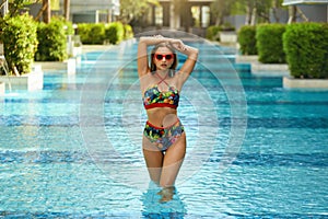 Summer fashion. Girl in swimsuit, sunglasses in swimming pool