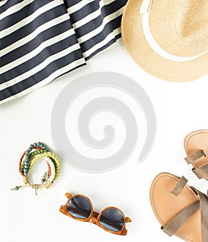 Summer fashion, summer outfit on white background. Blue striped dress, brown sandals, retro sunglasses, straw hat, wod bracelet. F