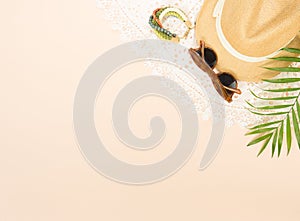 Summer fashion, summer stuff on cream background. White lace dress, retro sunglasses, wood bracelet and straw hat. Flat lay, top v