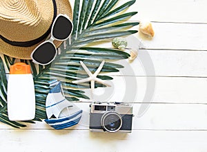 Summer Fashion woman big hat and accessories in the beach. Tropical sea.Unusual top view, white wood background.