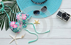 Summer Fashion woman big hat and accessories, vintage camera go to travel in the beach. Tropical sea.Unusual top view,