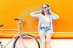 Summer fashion woman listens to music in headphones