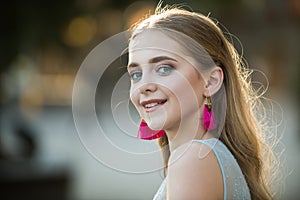 Summer fashion woman. Pretty girl with fashionable hair and pink earrings. Beautiful female. Beauty and fashion look of