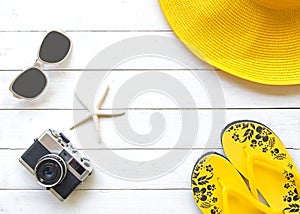 Summer Fashion woman yellow big hat and accessories in the beach. Tropical sea.Unusual top view, wood white background.