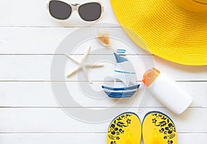 Summer Fashion woman yellow big hat and accessories in the beach. Tropical sea.Unusual top view, wood white background.