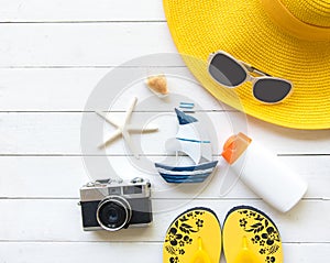 Summer Fashion woman yellow big hat and accessories in the beach. Tropical sea.Unusual top view, wood white background. photo