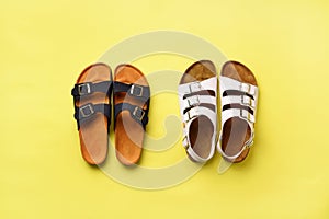 Summer female shoes - sandals birkenstock and slippers on yellow background with copy space. Top view. Minimal flat