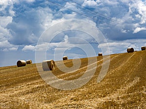 Summer Field with Hay Bales. under storm clouds.Agriculture Concept