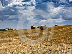 Summer Field with Hay Bales. under storm clouds.Agriculture Concept