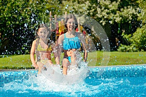 Summer fitness, kids in swimming pool have fun, smiling girls splash in water