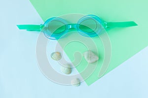 Summer flatlay with watersport goggles, mint and light blue background, minimalistic style, copy space