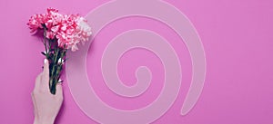 Summer flowers composition with girl hand isolated on pink background. Mother and women day. Valentine holidays concept. Top view