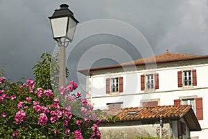 Summer flowers, lamp post and home in Sare, France in Basque Country on Spanish-French border, a hilltop 17th century village in