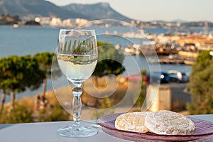 Summer on French Riviera, drinking cold white wine from Cotes de Provence on outdoor terrase with view on harbour of Toulon, Var,