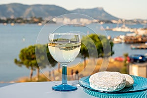 Summer on French Riviera, drinking cold white wine from Cotes de Provence on outdoor terrase with view on harbour of Toulon, Var,
