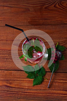 Summer fresh red currant ice tea in glass on dark background. Seasonal vitamins healthy food. Easy homemade recipe photo