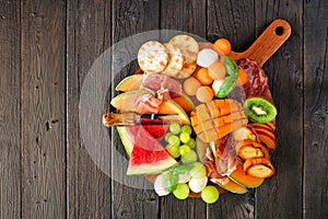 Summer fruit charcuterie board against a dark wood background. Top view. photo