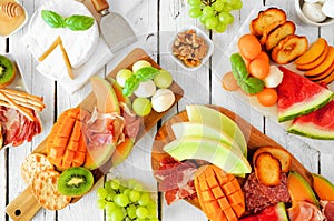 Summer fruit charcuterie table scene against a white wood background. Overhead view.