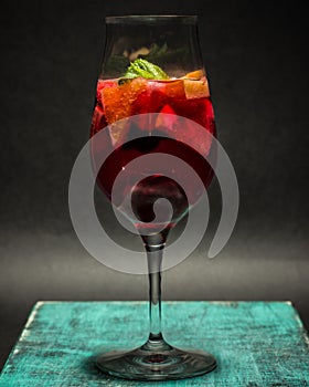 Summer fruit cocktail in glass , lemonade, studio photo, dark background