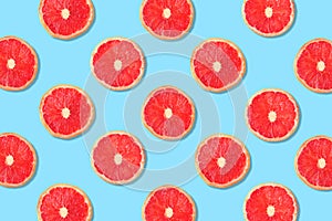 Fruit pattern of pink grapefruit slices on a blue background