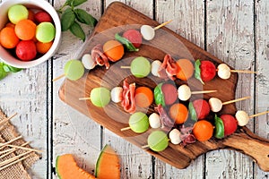 Summer fruit skewers on a wood serving board