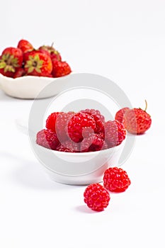 Summer fruits concept strawberry and rasberry in ceramic cup on