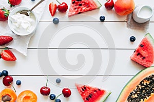 Summer fruits. Fresh juicy berries, watermelon and papaya on the white wooden table, top view