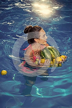 Summer fruits and vitamins. Dieting and healthy organic food, vegetarian. Vitamin in banana at girl sitting near water