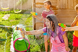 Summer fun - girl shoot water gun in group of kids