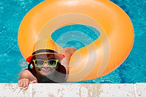 Summer fun kids face. Child boy 7, 8, 9 years old swim on floating ring in swimming pool. Kids summer funny face.