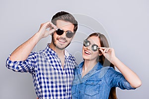 Summer and fun mood. Young students are wearing trendy sunglasses and smile, in casual shirts, posing on the pure background. Pret