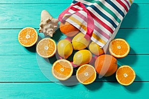 Summer fun time. Fruits on blue wooden background. Orange, lemon fruit in bag on table. Top view and mock up. Copy space. Sea