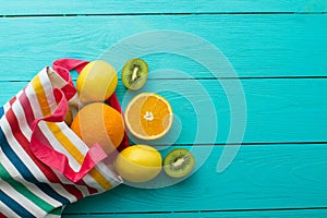 Summer fun time and fruits on blue wooden background. Orange, lemon, kiwi fruit on table. Top view and mock up