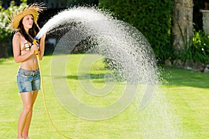 Summer garden woman play with water hose