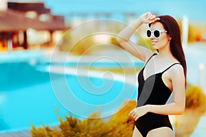 Summer Girl with Fashion Sunglasses and Black Swimsuit by the Pool
