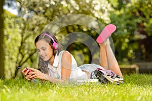 Summer girl lying grass listen music headphones