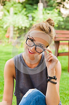 Summer girl portrait. Caucasian blonde woman smiling happy on sunny summer or spring day outside in park