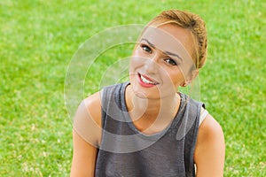 Summer girl portrait. Caucasian blonde woman smiling happy on sunny summer or spring day outside in park