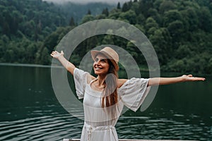 Summer girl portrait. Young woman smiling happy on sunny summer or spring day outside in park by lake.