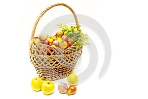 Summer harvest is in a wooden basket - vegetables and fruits on white background