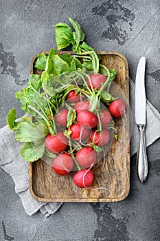 Summer harvested red radish. Growing organic vegetables. Large bunch of raw fresh juicy garden radish , on gray stone background,