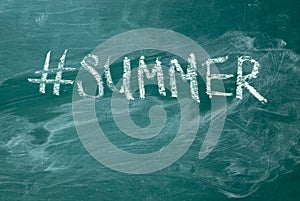 Summer hashtag it handwritten with white chalk on a green blackboard