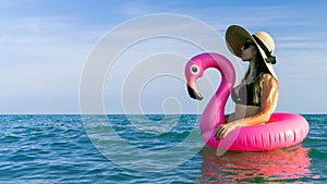 Summer hat beach. Happy young sexy girl in bikini swimsuit, sunglasses and straw hat with pink inflatable flamingo in blue sea