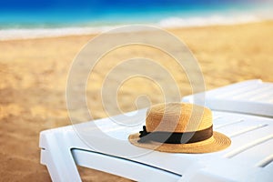 Summer hat on the beach lounger on the background of sand and sea