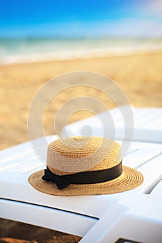 Summer hat on the beach lounger on the background of sand and sea