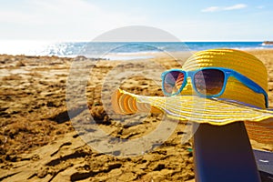 Summer hat and sunglasses on beach