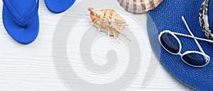 Summer hat and sunglasses with sandals and shells